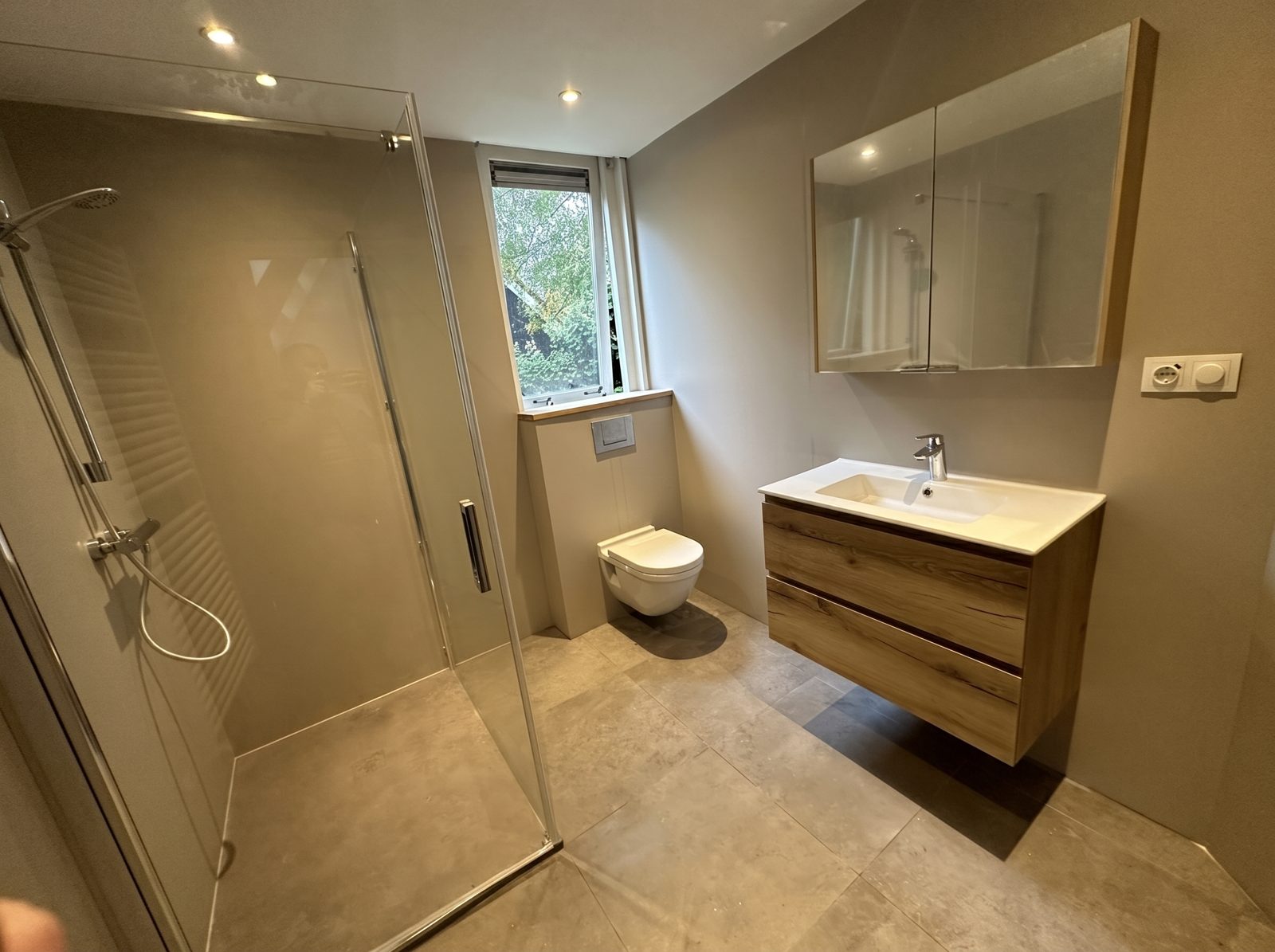 Complete badkamer met inloopdouche, houten wastafelmeubel en veel daglicht